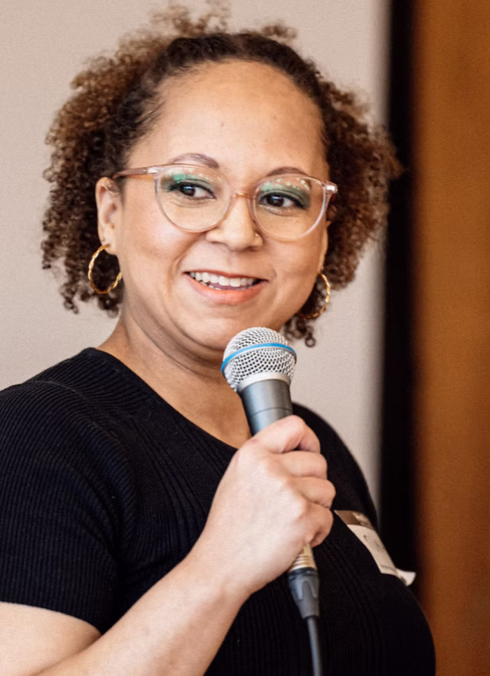 Community leader speaking into a microphone during a panel discussion at the Fircrest Black History Month celebration.