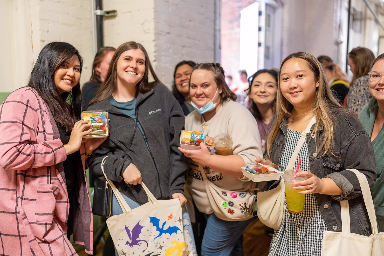Guests smiling with drinks and event favors during a lively community event coordinated by Cute Story Events.