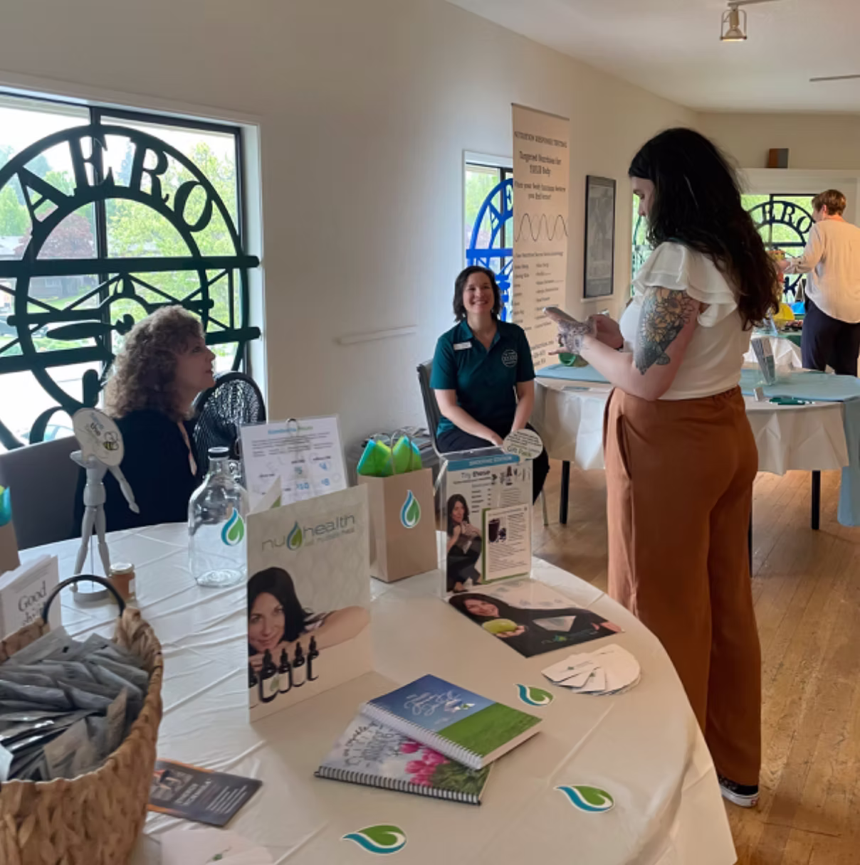 Guests visiting wellness and self-care vendor booths during a community event hosted by Sculpt Bodywork.