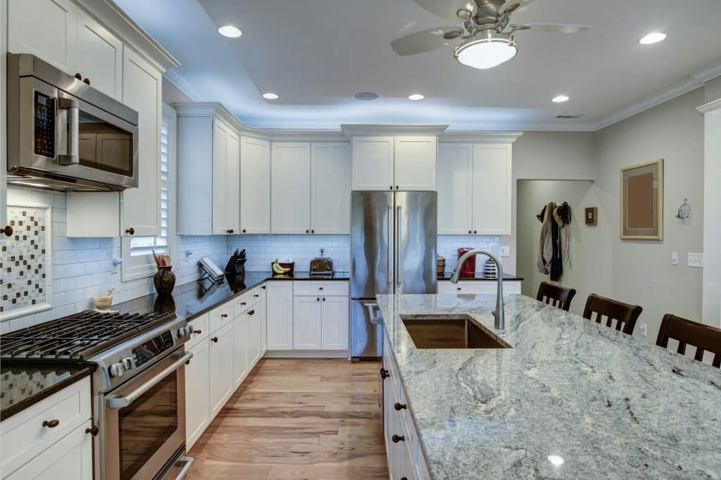 Amazing quartz countertop fabrication and installation in Snohomish & King Counties | Beautiful luxury kitchen with quartz and granite countertops and white cabinets.
