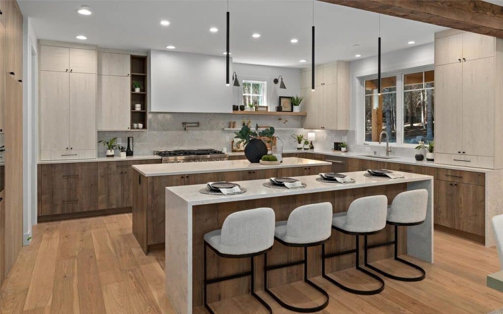 Contemporary open-concept kitchen with warm wood tones, waterfall island, and integrated bar seating.