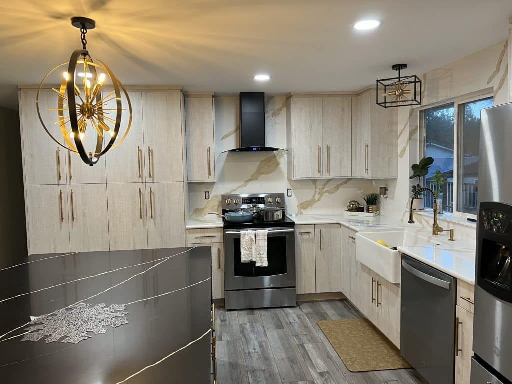 Two-tone kitchen remodel featuring light upper cabinets, dark lower cabinets, and stylish lighting fixtures.