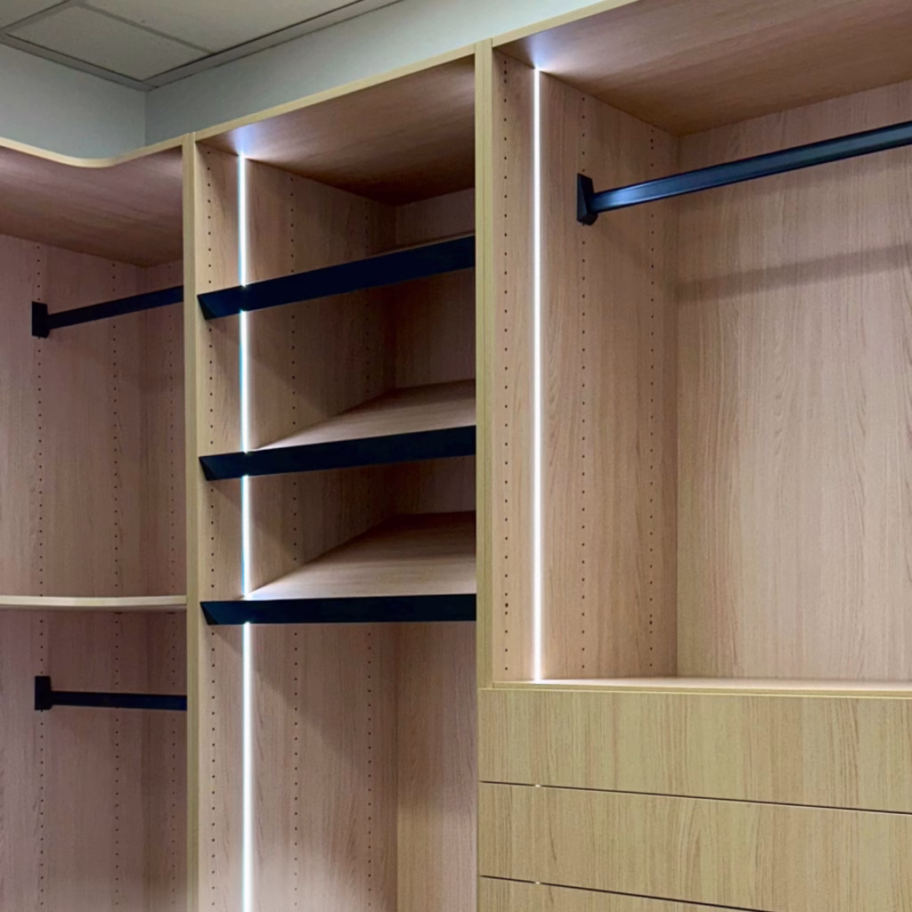 Modern custom-built closet with open shelving, hanging space, and built-in drawers, designed for organized storage and a clean, streamlined look