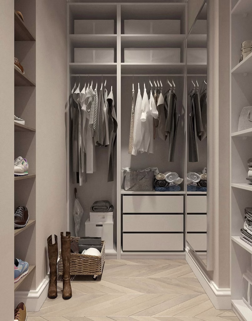 Modern walk-in closet with open shelving, hanging space, drawers, and herringbone wood flooring, featuring neutral-toned clothes and accessories neatly organized.