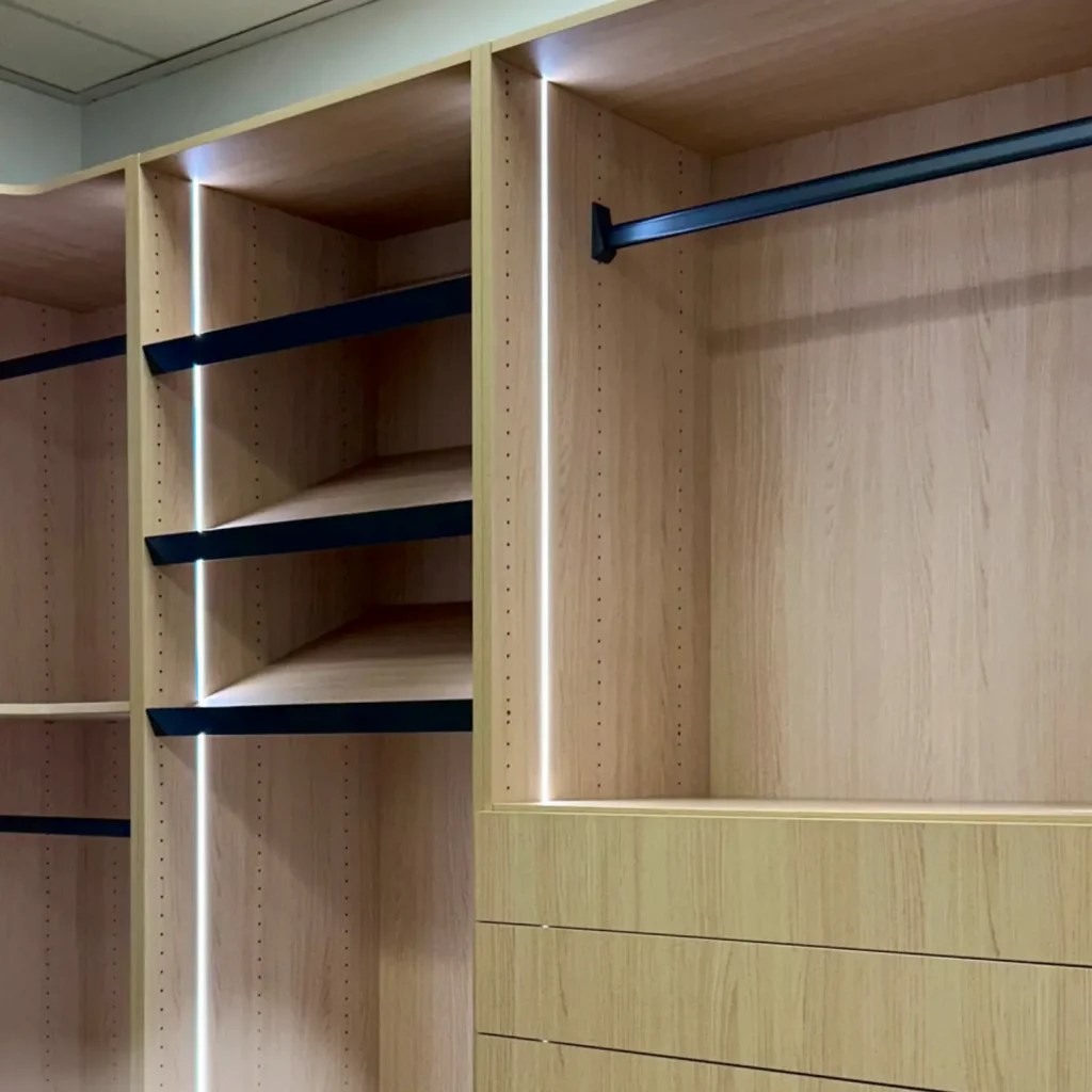 Modern custom-built closet with open shelving, hanging space, and built-in drawers, designed for organized storage and a clean, streamlined look