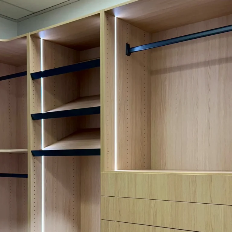 Modern custom-built closet with open shelving, hanging space, and built-in drawers, designed for organized storage and a clean, streamlined look