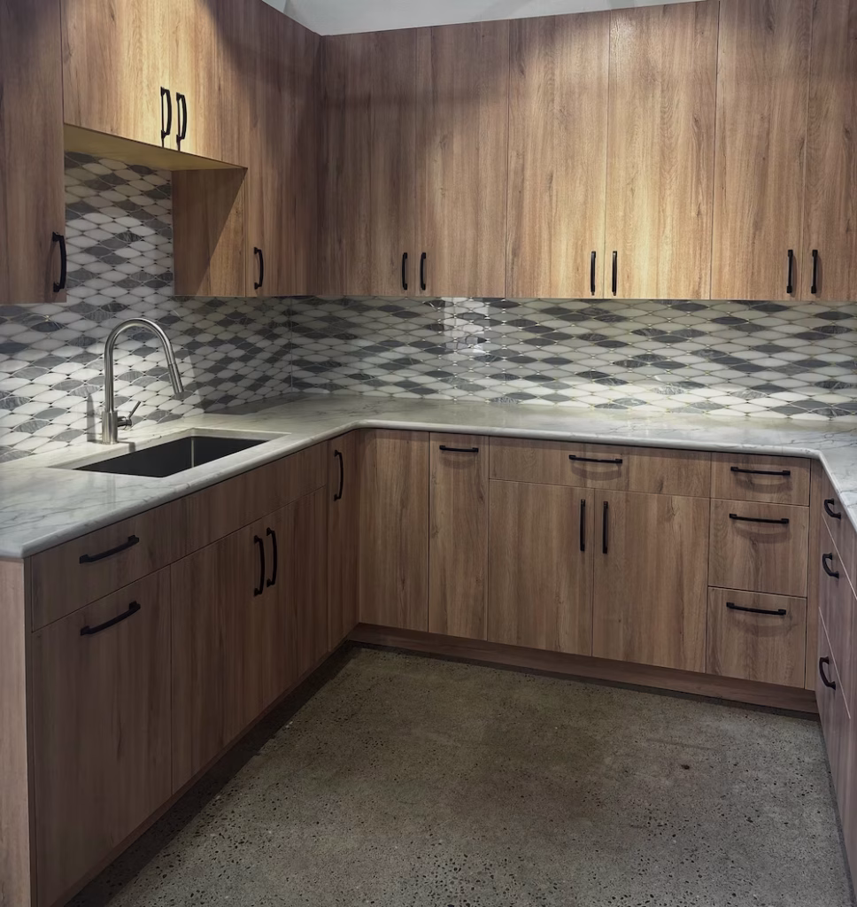 Rustic-modern kitchen with natural wood cabinets and geometric tile backsplash for a warm, textured look.