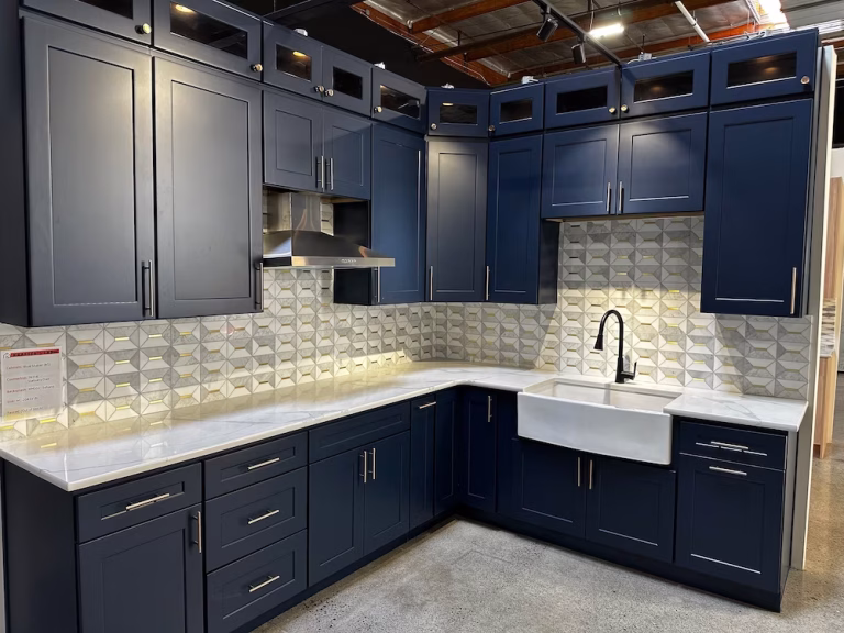Navy blue custom cabinetry with farmhouse sink and 3D tile backsplash, designed by Iconic Cabinetry.