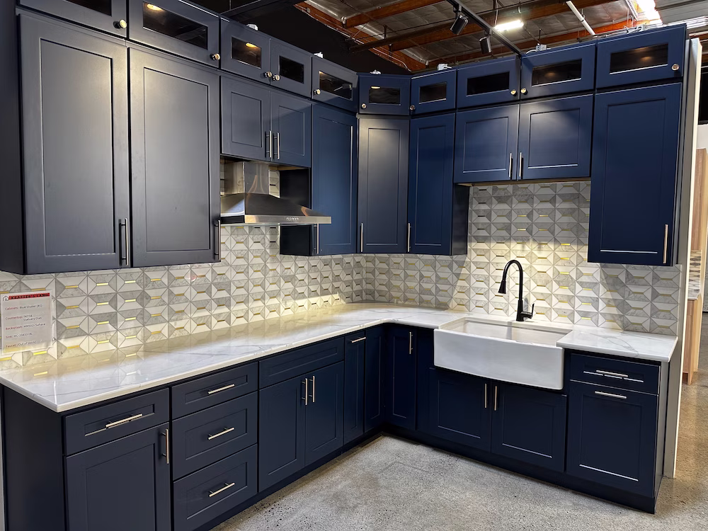 Navy blue custom cabinetry with farmhouse sink and 3D tile backsplash, designed by Iconic Cabinetry.