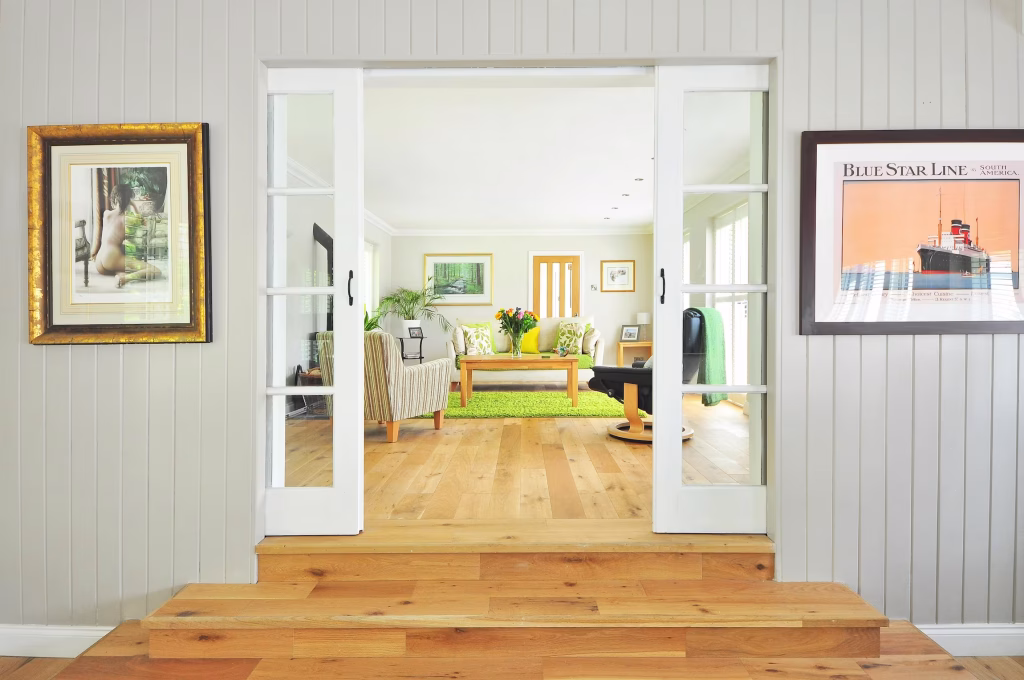 Bright living room remodel with natural wood flooring, white sliding doors, and updated trim and molding