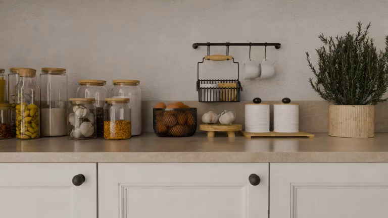Modern Seattle kitchen remodel with white shaker cabinets, neutral stone countertops, and minimalist storage jars on display