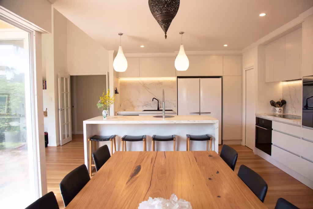 Modern Seattle kitchen remodel with marble waterfall island, pendant lights, and open layout dining area