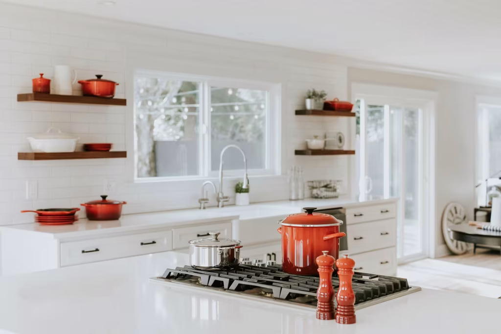 Bright Seattle kitchen remodel with quartz countertops, red cookware accents, and large windows