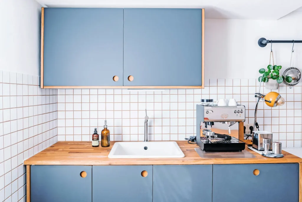 Small kitchen remodel with blue cabinets, butcher block countertop, and espresso machine station