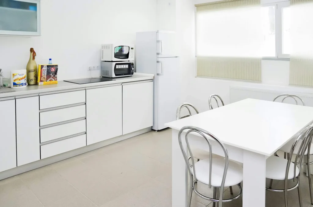 Minimalist all-white kitchen with chrome accents and no warmth, an outdated design trend for 2026