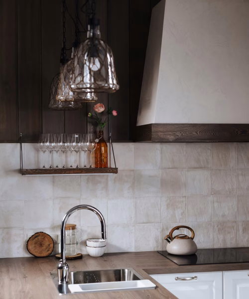 Minimalist kitchen wall with white square tile backsplash, wood shelving, and indoor plants for a cozy natural aesthetic